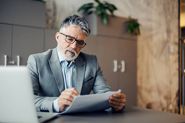 istock Mature businessman working on paperwork in office 2260504040