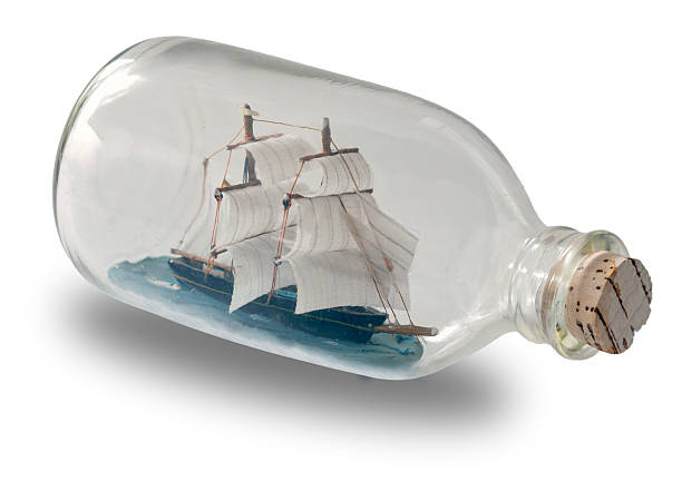 Ship in a Bottle. Small ship model in a bottle with a cork stopper on white background.