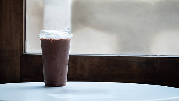 Glass of iced cocoa or chocolate drink with milk. Refreshing cold beverage in a cafe.