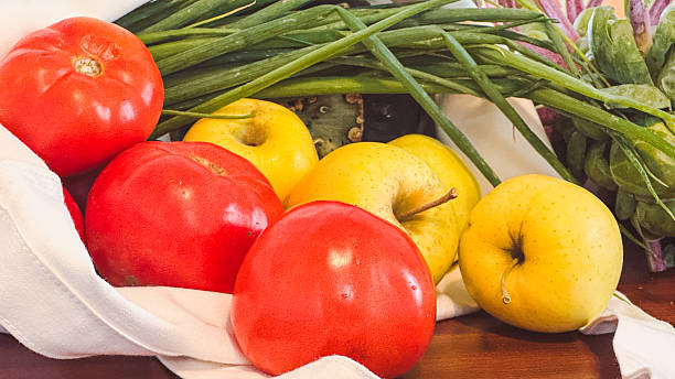 Organic vegetables from a local farm market sit on a kitchen table.