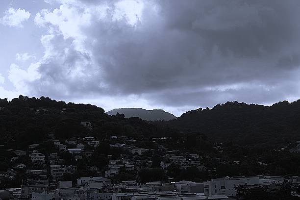 A hot, wet tropical storm in St Lucia, featuring rain, dark skies, and looming clouds