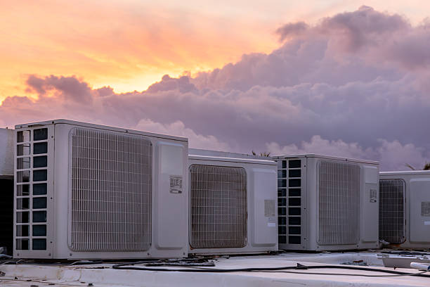 Hotel cooling systems on rooftop at sunrise in tropical resort