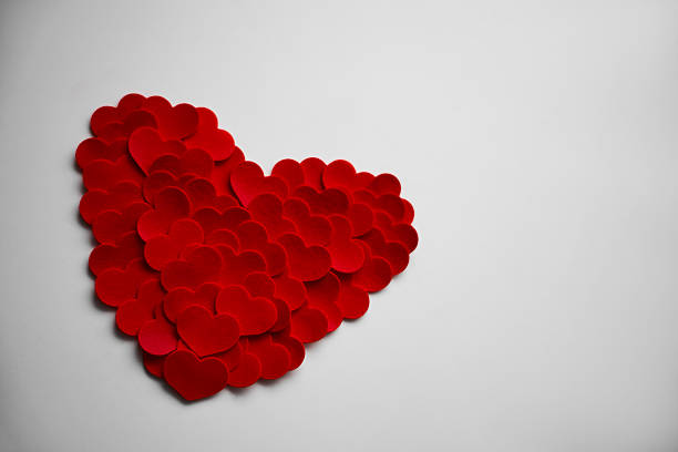 3 red paper hearts laid out on a wooden table