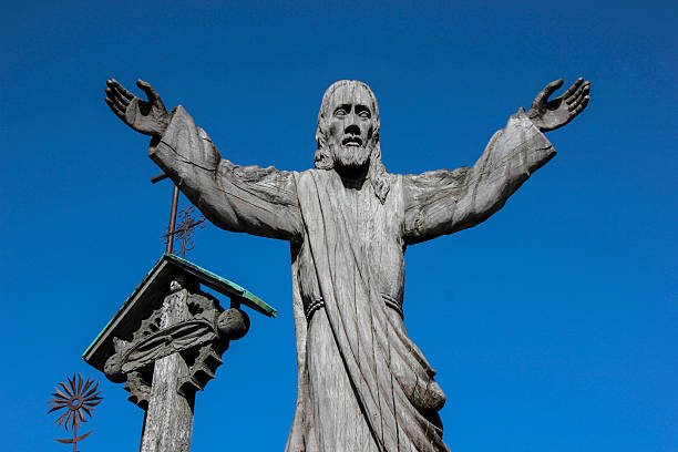large crucifix with gold-plated Jesus under a huge tree in a small village in Upper Bavaria