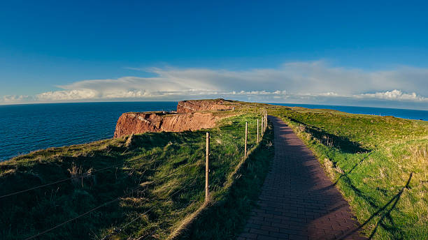 View of walkways and paths on cliffs facing the sea during sunset