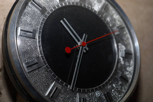 A classic wall clock with a round black dial and a metal case reflects the aesthetics of Soviet modernism.