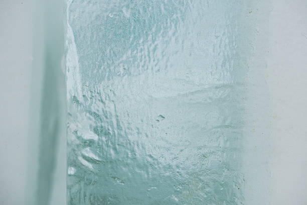 Abstract winter scene featuring translucent ice blocks resting on fresh white snow, showcasing frozen textures, cool tones, and minimalist natural forms in a cold outdoor environment