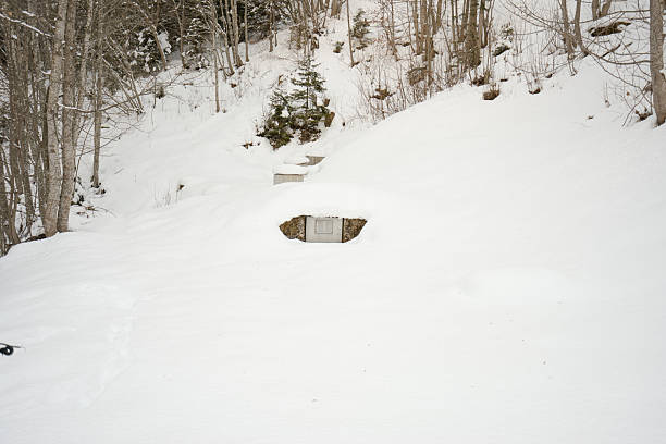Underground bunker entrance blending into a snow-covered hillside landscape during winter