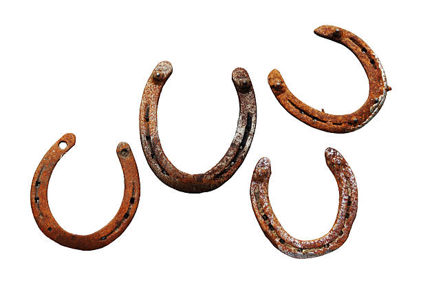 Closeup of a generic horseshoes game on a lawn in the sunshine.