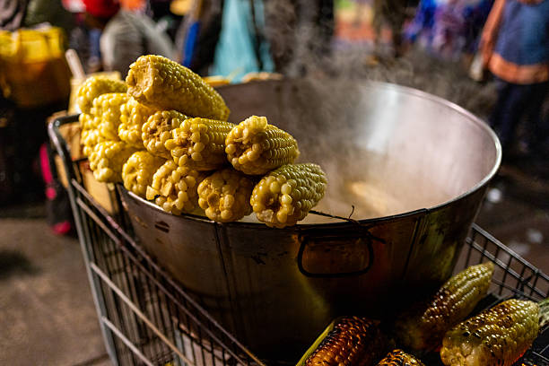 Street vendors sell corn as a snack at events in Mexico. Corn is boiled in large pots and then seasoned for consumption. Photo was taken in Mexico City during the evening.