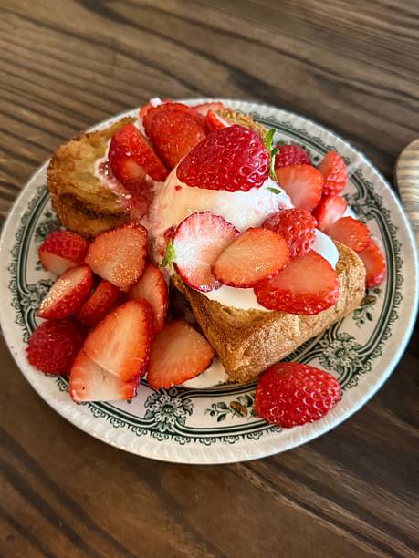 Golden French toast topped with fresh strawberries, offering a soft, custardy texture and gentle sweetness. Warm, inviting, and visually appealing, perfect for cozy breakfast or brunch moments.