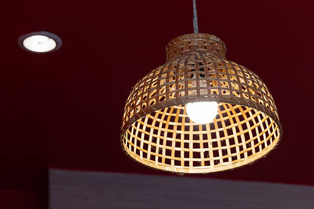 A lamp with a light bulb hanging from a basket shaped lampshade. weaving bamboo lantern. handmade hanging woven lamp.