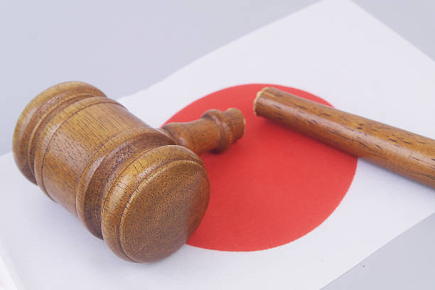 Broken judge gavel on flag of Japan. Injustice in Japan concept.