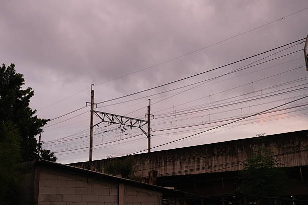 A moody landscape featuring a mist-covered hillside with telecommunication and power towers emerging from the fog. The diffused light and hazy atmosphere create a mysterious and dramatic scene. The contrast between the industrial structures and the natural environment highlights the presence of technology in remote landscapes.