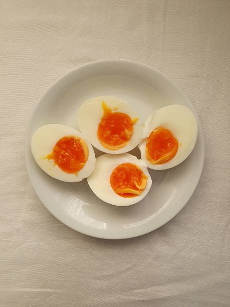 Boiled egg with smooth white exterior and firm yellow yolk inside, showcasing its simple appearance and versatile use as a nutritious and classic food item