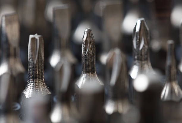 A bunch of screwdrivers with a pointed end. Some are silver and some are black. They are all lined up
