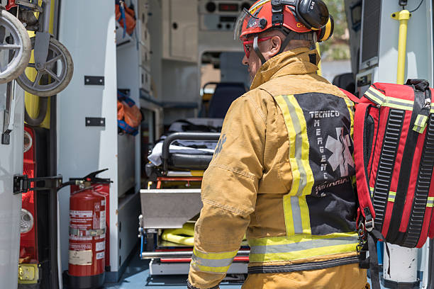Emergency medical technician is standing inside an ambulance with the doors open, ready to respond to an emergency situation