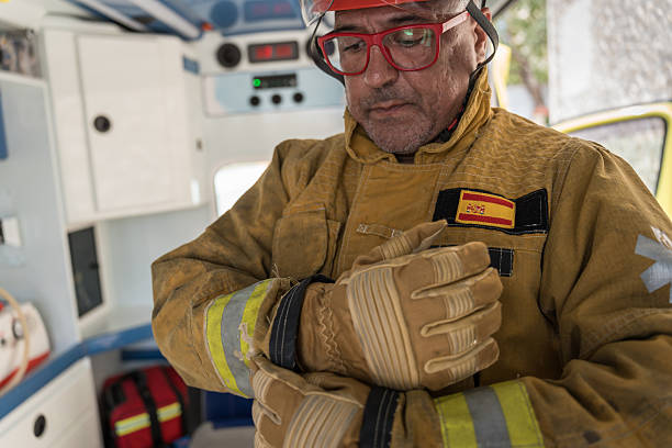 Firefighter carefully putting on his protective gloves inside the firetruck, getting ready for a rescue operation