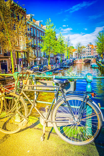 traditional bicycles standing next to canal in Amsterdam, Netherlands