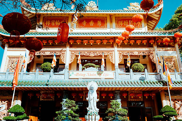 Scenic view of a passageway in Da Nang, Vietnam, adorned with vibrant flowers and hanging lanterns. The festive decorations highlight the city’s cultural charm and traditional celebration atmosphere, creating a colorful and inviting scene