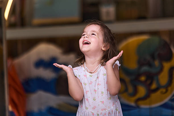 Child sitting in an inflatable watermelon swim ring, getting ready for beach summer vacation, isolated on yellow colored background