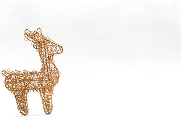 A brass wire mesh reindeer Christmas ornament on a white background.  Could be used for greetings card.