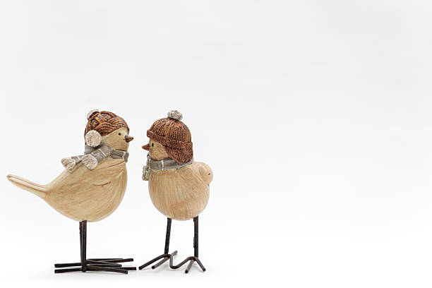 Two Christmas bird ornaments facing each other on a white background as if talking to each other.  Plenty of copy space.  Could be used for a greetings card.