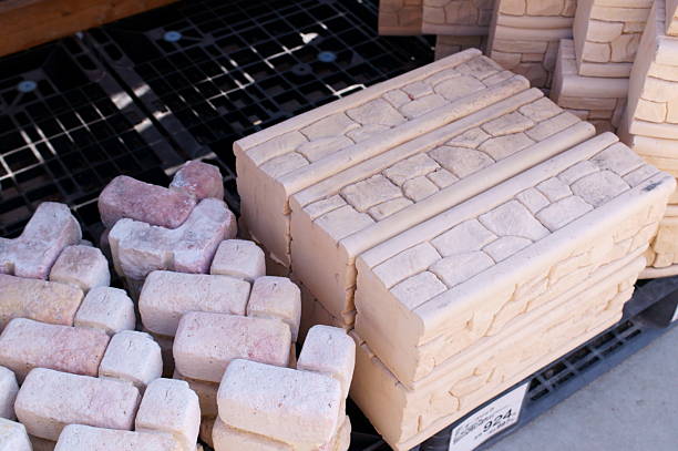 A group of white blocks is arranged creatively on a wooden surface. The blocks are being placed carefully, showcasing an engaging building activity in a calm setting.