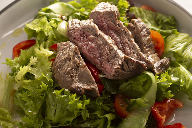 Square stock image of restaurant meat setting with grilled steak, greens and hot red sauce