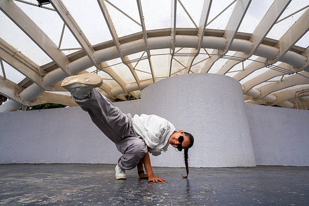 Woman performing a hip hop dance pose outdoors with confident expression