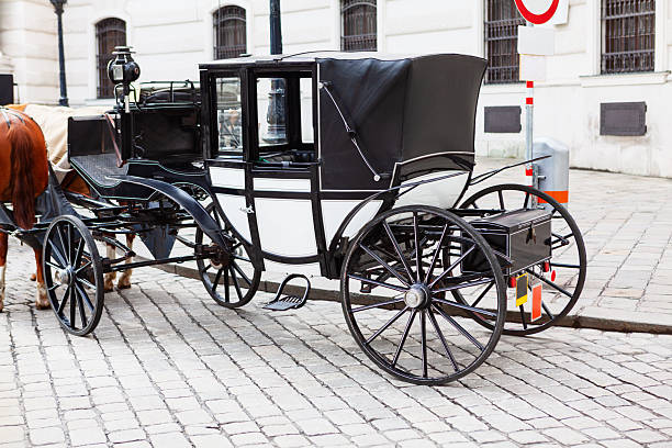 Landau carriage, popular choice for tours in Vienna, is ready on the cobbled streets for passengers. Historical setting is ideal for these traditional four-wheeled, convertible vehicles