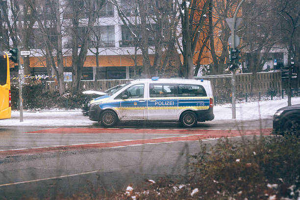 Berlin, Germany – January 31, 2026: A German police van marked “POLIZEI” is stopped on a winter street with visible front-end damage, with snow and slush on the roadside. The scene suggests a traffic incident or collision under cold weather conditions, highlighting winter road hazards such as ice and slippery surfaces.