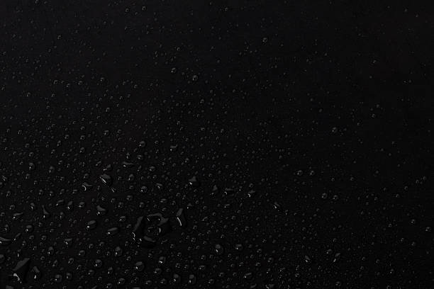 istock Water droplets scatter on a dark surface after rain, creating a shiny appearance and reflecting light during the early morning 2260727722