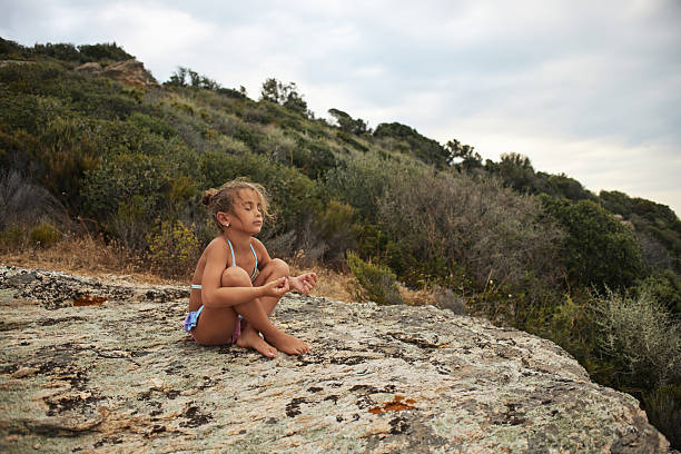 Little girl practicing mindfulness and yoga outdoors, finding peace in nature