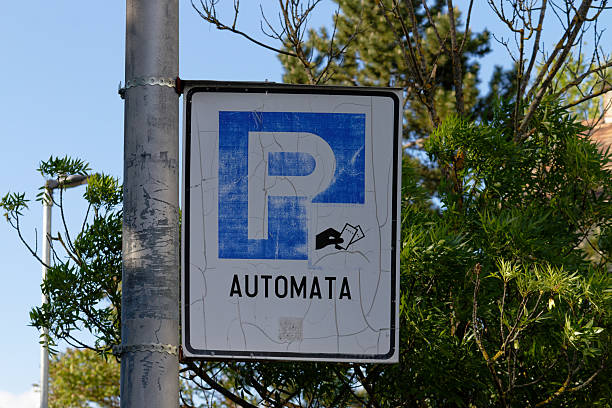 A weathered parking sign indicates an automated payment system for vehicle parking