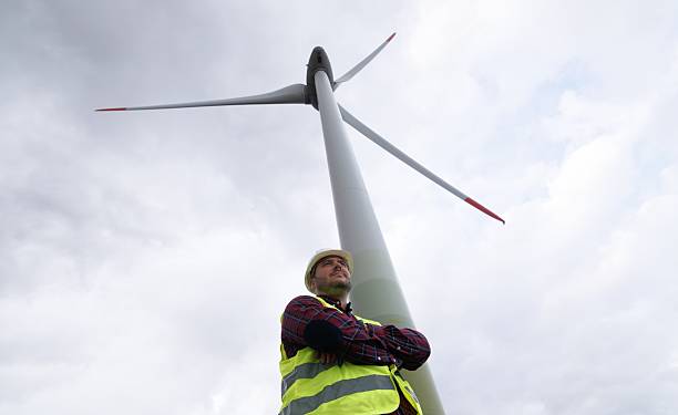 Engineer in front of a wind turbine. Clean energy.