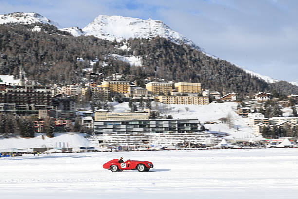 View of beautiful night lights of St. Moritz town in Switzerland at night in winter, with reflection from the lake and snow mountains in backgrouind