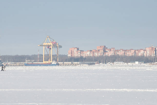 Frozen River With Distant Crane Skyline, Pale Winter Light Over Icy Expanse, Lowcontrast City Blocks