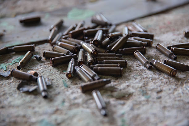 Spent shell casings littering a dirty, worn concrete ground, symbolizing conflict and danger