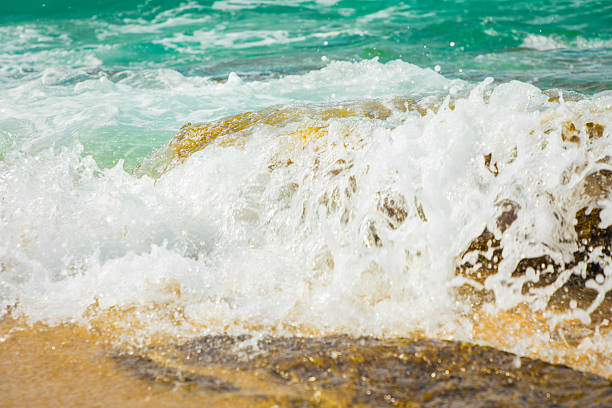 A powerful wave of the Mediterranean sea crashes against the rocks, creating a massive splash and beautiful, white foam,Beautiful seascape that can be used as a backdrop