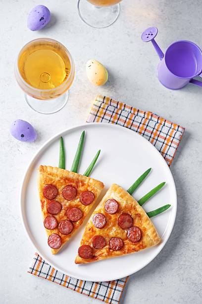 Pizza mini with tomato sauce and sausages in the form of carrots in a plate for Easter holidays