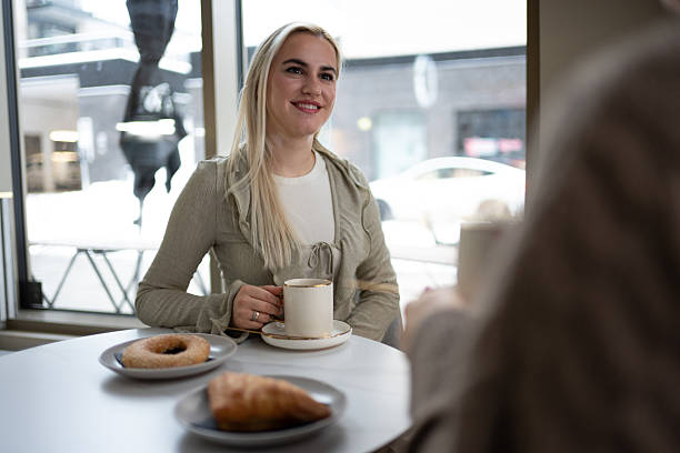 Young woman enjoying coffee and pastry in cafe.