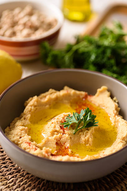 Healthy vegan snack, chickpea hummus dip topped with paprika and fresh parsley