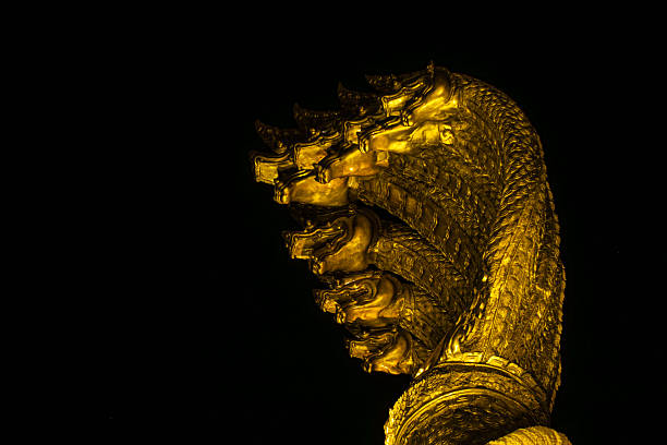 Phaya Sri Satta Nakarat Naga statue Nakhon Phanom Thailand, sacred Mekong River serpent, Thai Buddhist mythology landmark, ornate multi-headed Naga with offerings under dramatic cloudy sky, spiritual cultural mood
