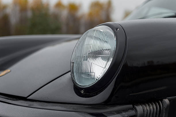 Vilnius, Lithuania - October 7, 2025: A front headlight of a black Porsche 911 SC. European specification headlight.