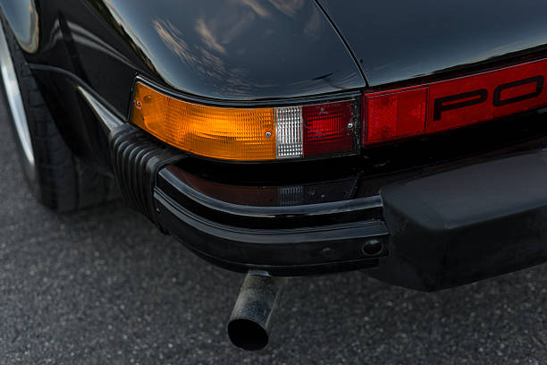 Vilnius, Lithuania - October 7, 2025: A rear end view to a black Porsche 911 SC. Three quarter close up view to blinker lights and exhaust pipe.
