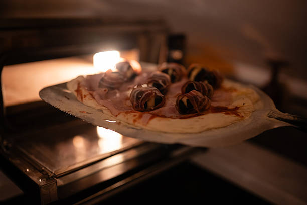 Preparing gourmet pizza with figs and ham for baking
