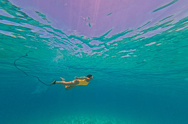Photo of a young woman diving and exploring wonderful underwater world