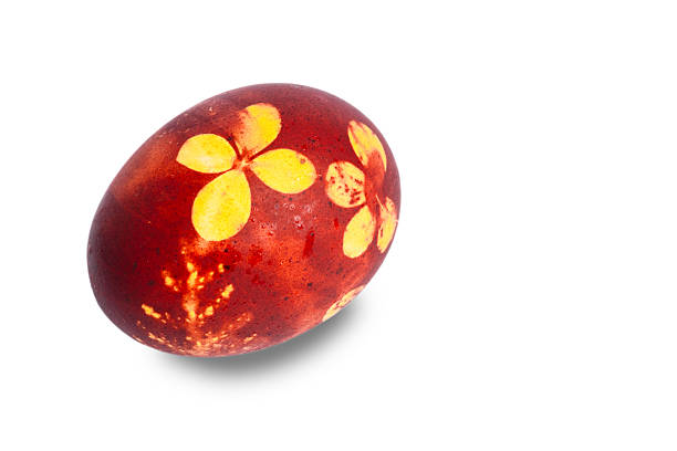 A traditionally dyed Easter egg with a leaf pattern on a dark background