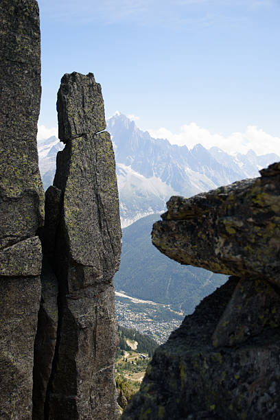 Dramatic rock formations frame a view of Mont Blanc and Chamonix during a clear day